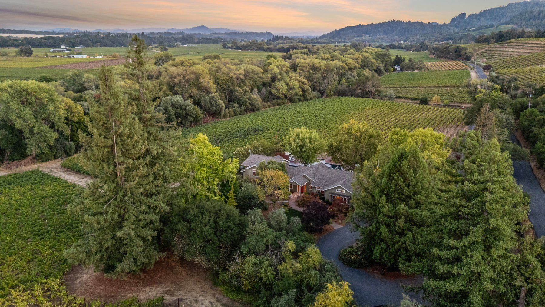 Creekfront twilight aerial of the front grounds